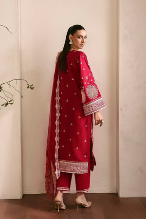 Woman wearing a red embroidered traditional outfit with a plain background
