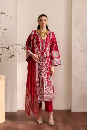 Woman wearing a red and white embroidered traditional outfit in a minimalistic setting.