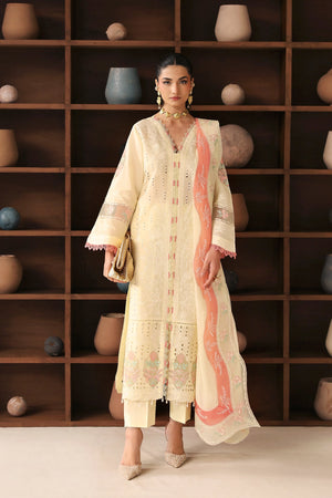 Woman in a cream embroidered outfit standing in front of a wooden shelf with decorative pots.