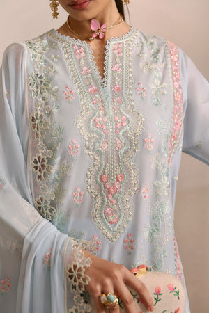 Light blue embroidered dress with floral patterns, held by a person.