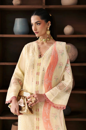 Woman in a traditional outfit with intricate designs, holding a decorative item, against a wooden shelf background.