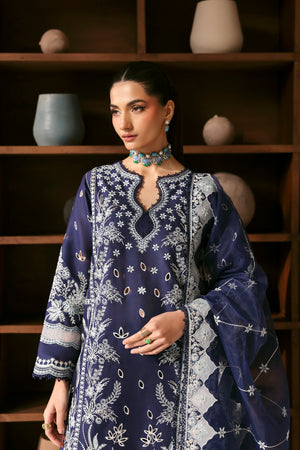 Woman wearing a blue embroidered outfit with a dark background