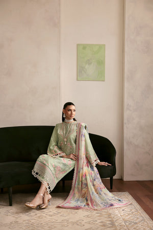 Woman in traditional outfit sitting on a black sofa with a painting on the wall.
