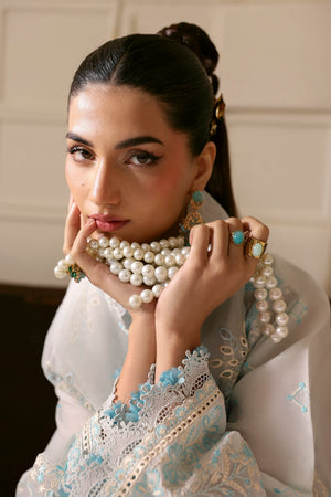 Woman wearing a pearl necklace and jewelry with a neutral background